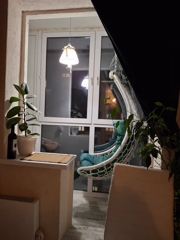 Квартира с подвесными креслами из ротанга на панорамной лоджии