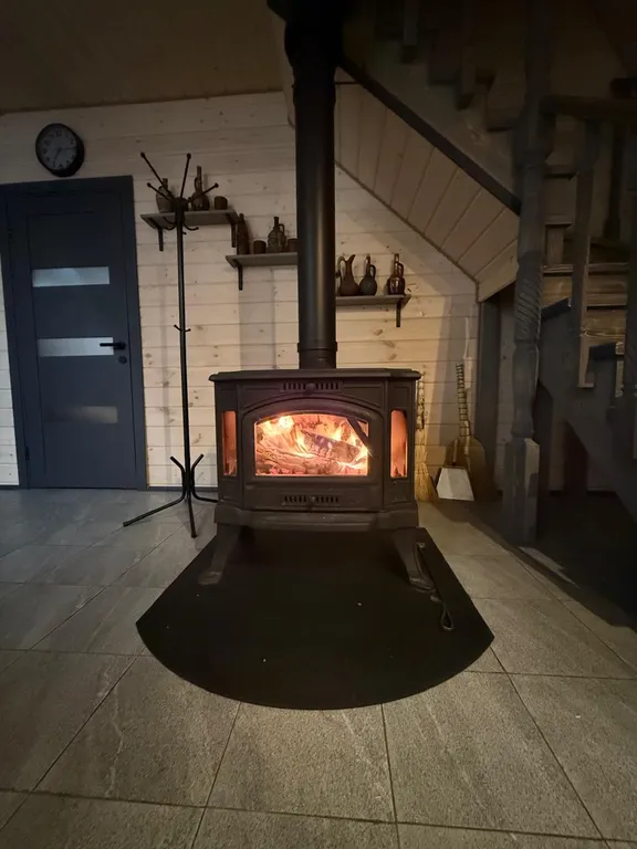 Большой треугольный домик с камином, с ванной у окна с видом на лес