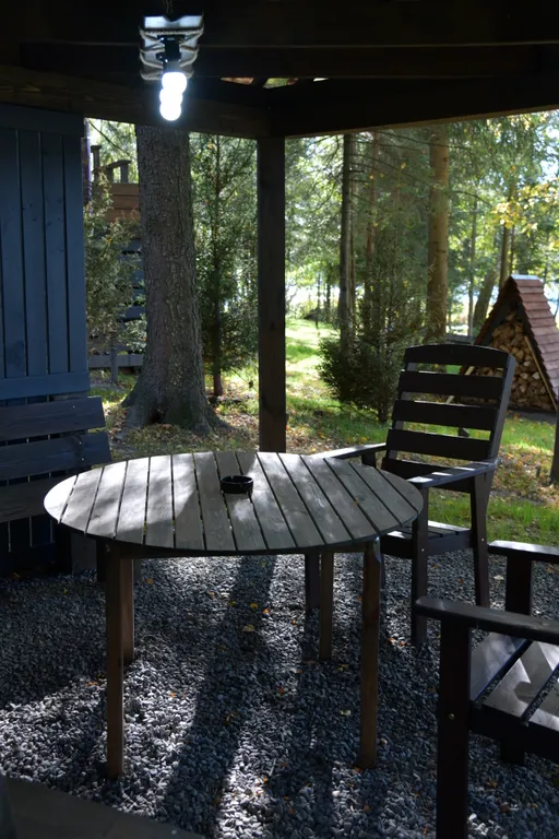 Дом с панорамными окнами в чаще леса у берега реки