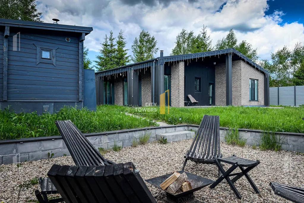 Новый дом в окружении елок с панорамными окнами и баней