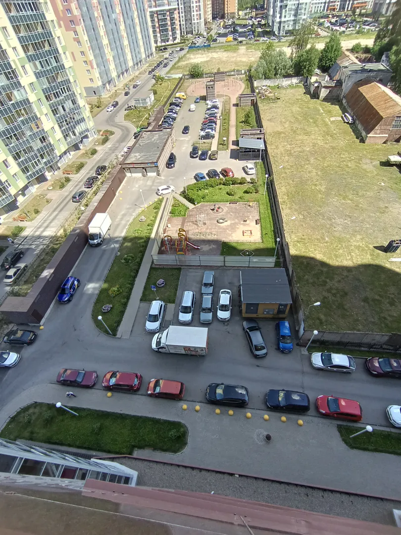 Фото огороженного двора: свободная парковка, детские площадки, платный паркинг  и зона мусоросбора. 