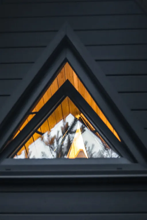 Треугольный домик на склоне горы над ручьём