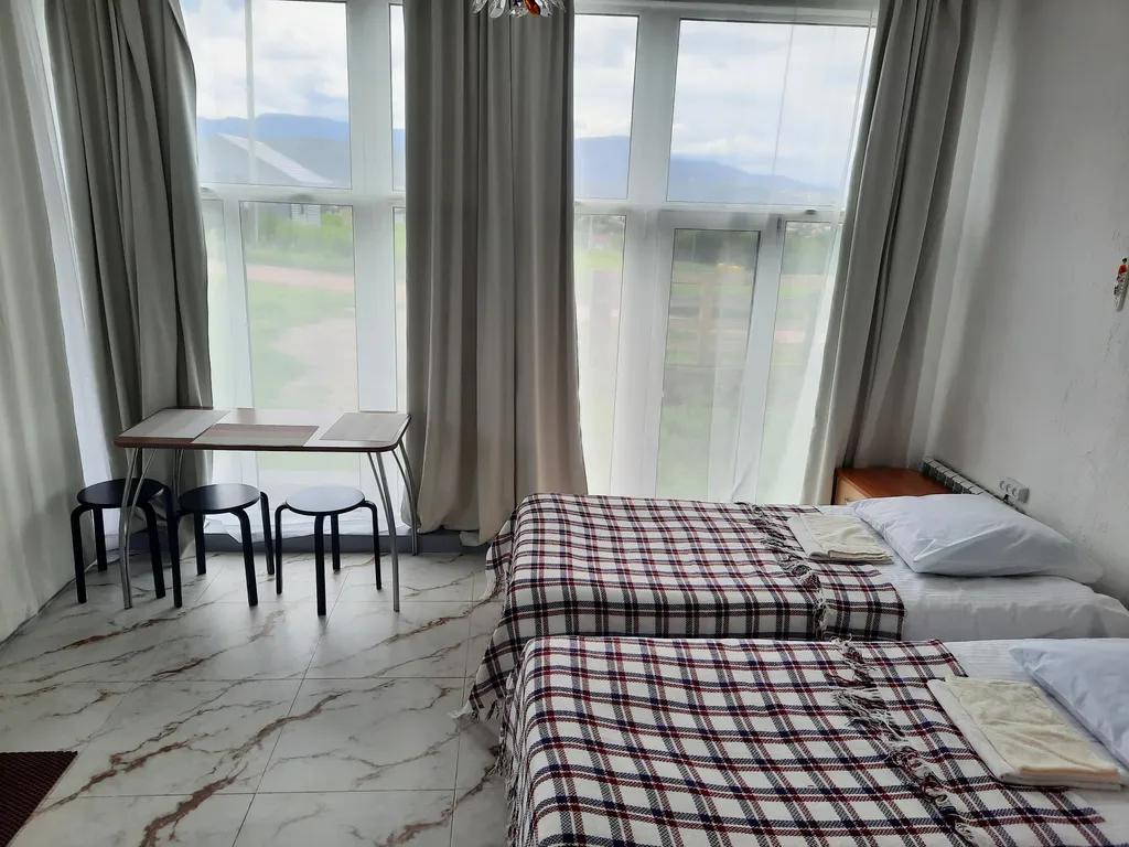 Комната с окнами в пол с видом на горы Белокурихи и город