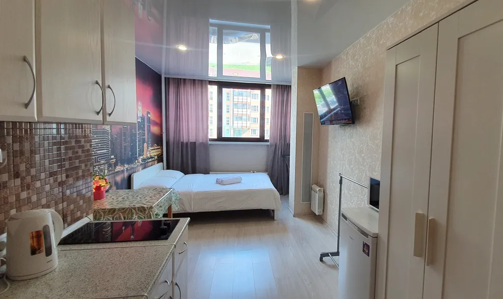 Уютная студия Мегаполис с большими окнами и плотными шторами