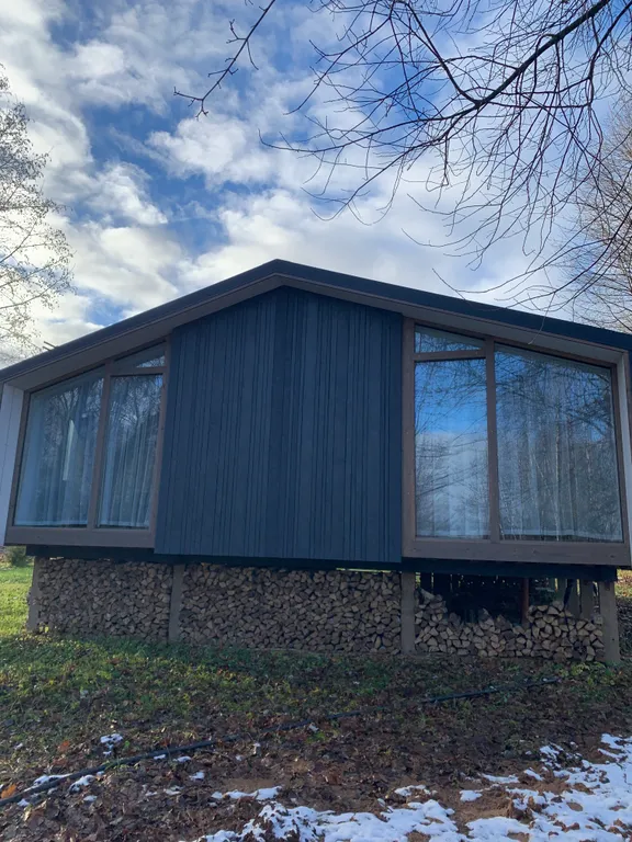 Дом с панорамными окнами в окружении леса