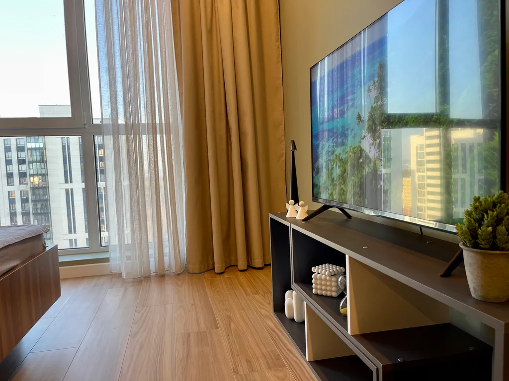 Новая квартира с кроватью возле панорамного окна, высокий этаж