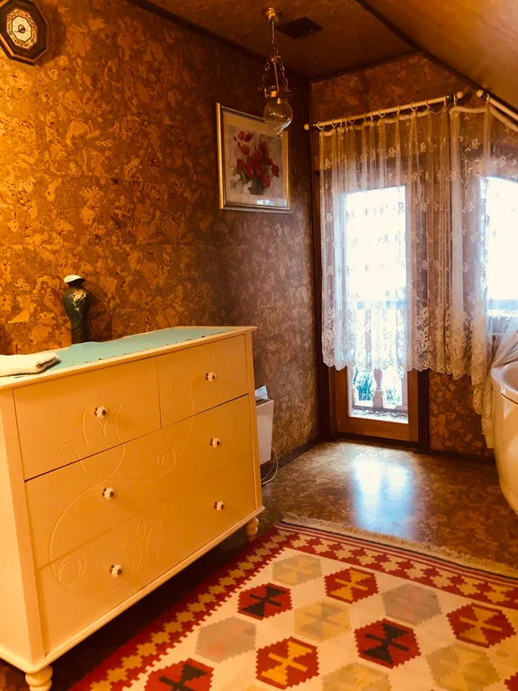 Изба (дом) из экологически чистого бревна под камышовой крышей в лесу