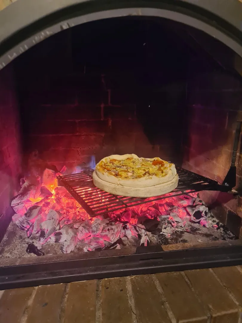 В камине можно установить специальную решетку и приготовить пиццу на камне для пиццы.