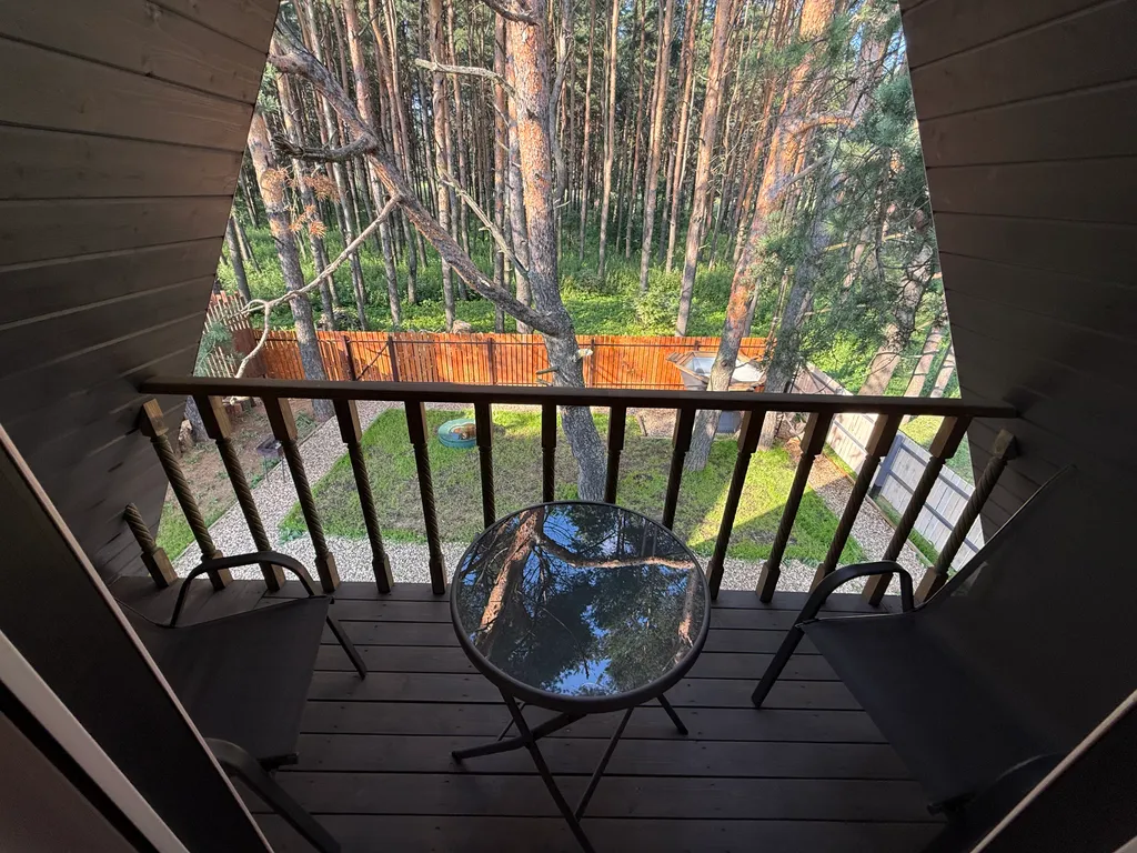 Большой треугольный домик с камином, с ванной у окна с видом на лес