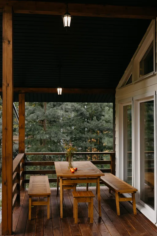 Дом с панорамными окнами и террасой в окружении леса