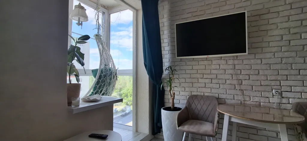 Квартира с подвесными креслами из ротанга на панорамной лоджии