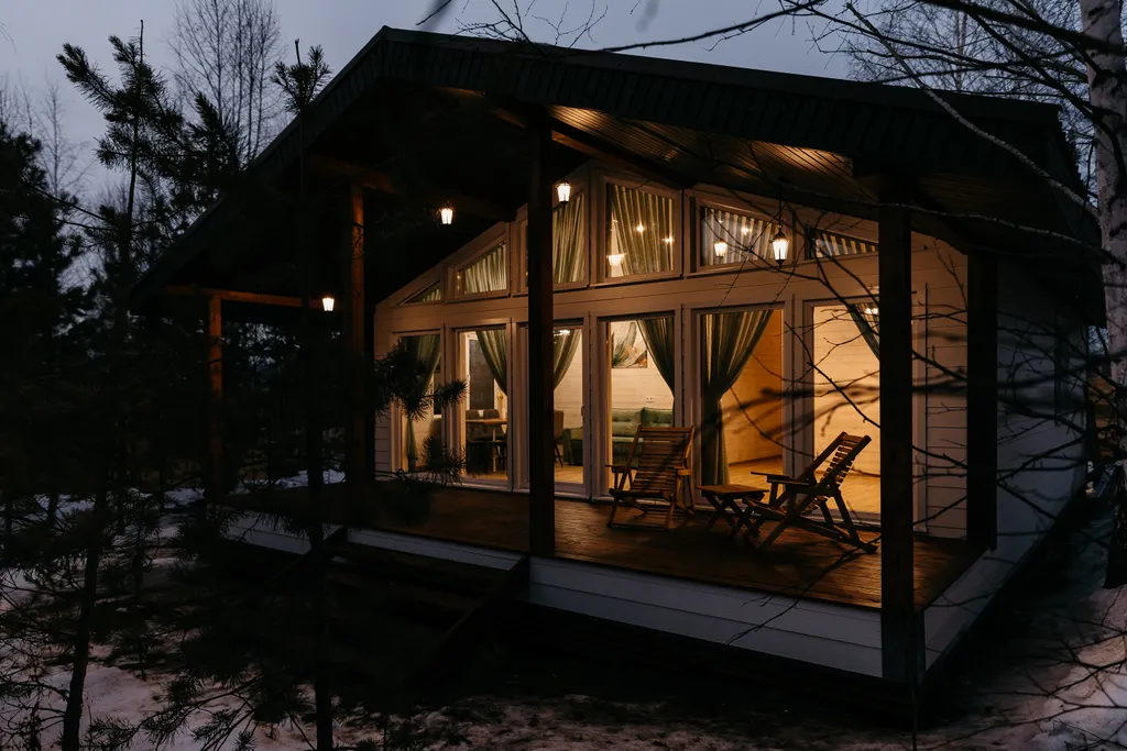 Дом с панорамными окнами и террасой в окружении леса