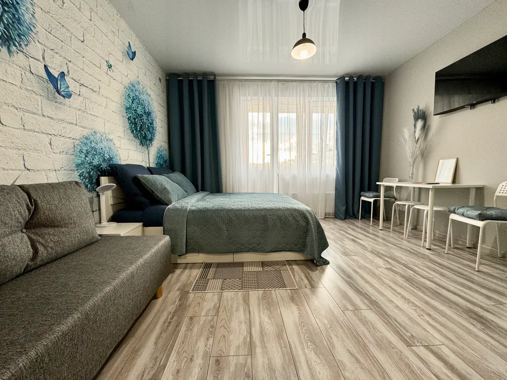 Уютная квартира-студия с большой кроватью и диваном