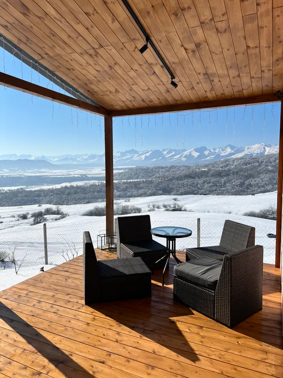 Домик на холме с видом на лес и горы