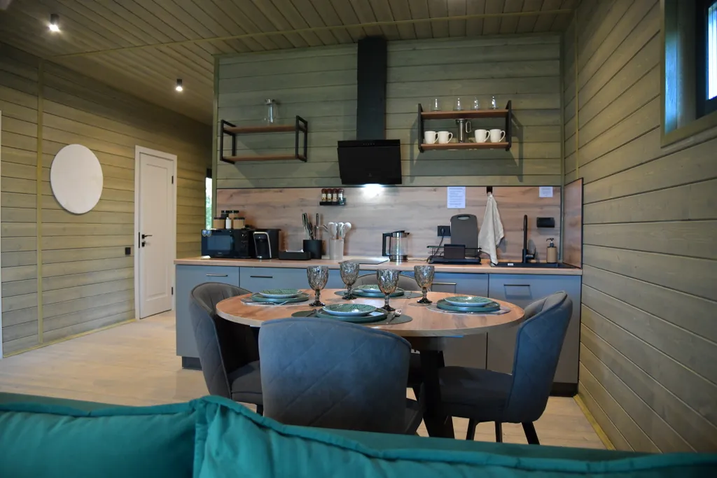 Дом с панорамными окнами в чаще леса у берега реки