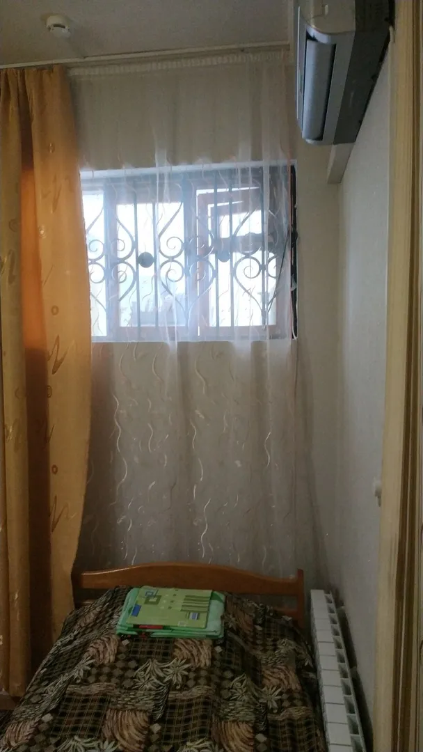Односпальная деревянная кровать и окно в сторону кухни