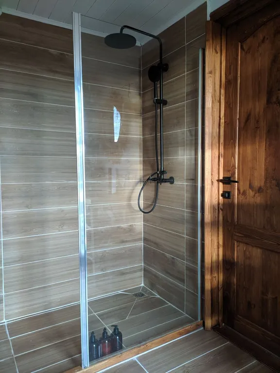 Лесной домик a-frame с террасой на холме, среди высоченных елей и берез