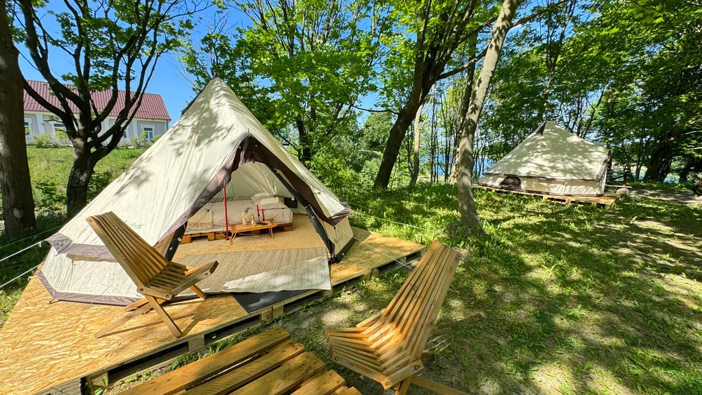 Уютный шатер среди деревьев на берегу озера