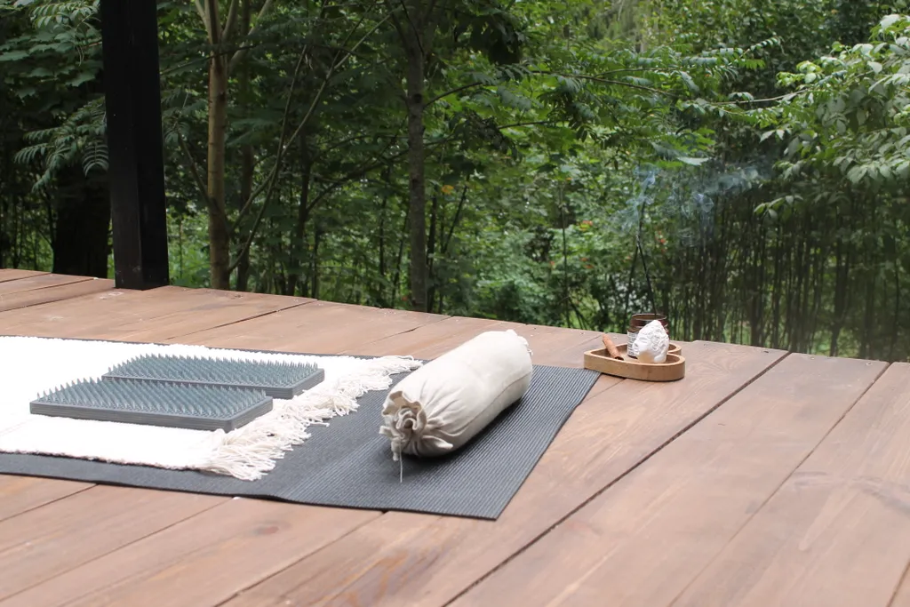 Дом с ванной у панорамных окон и высокой террасой в лесу