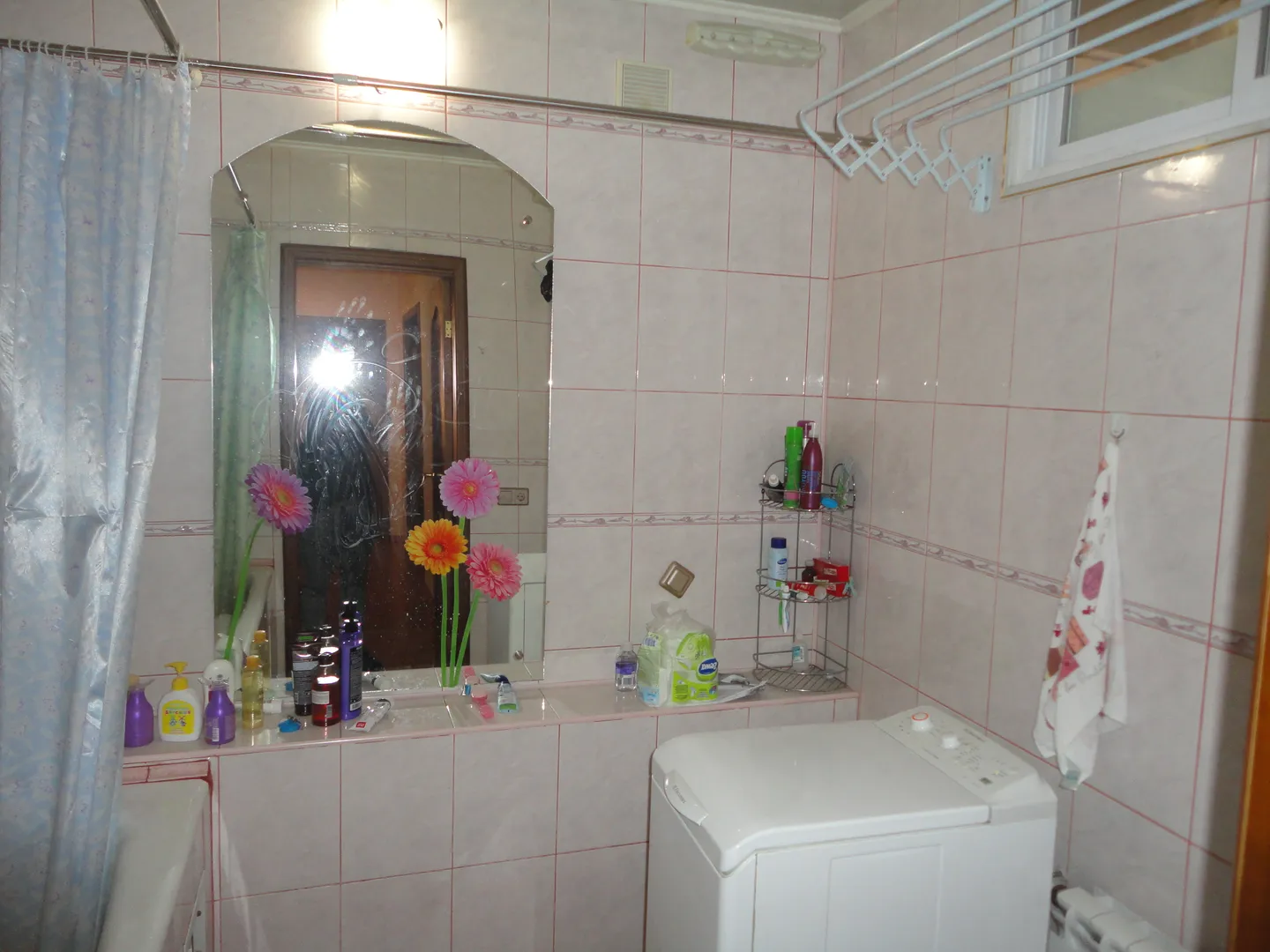 Просторная ванная комната с большим удобным зеркалом, настенной сушилкой для белья, современной стиральной машинкой.
