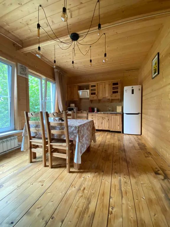 Деревянный дом на берегу реки с беседкой