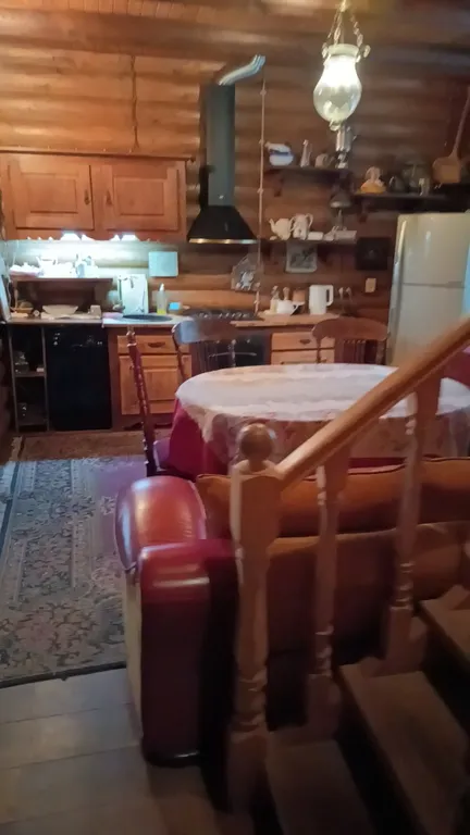 Изба (дом) из экологически чистого бревна под камышовой крышей в лесу