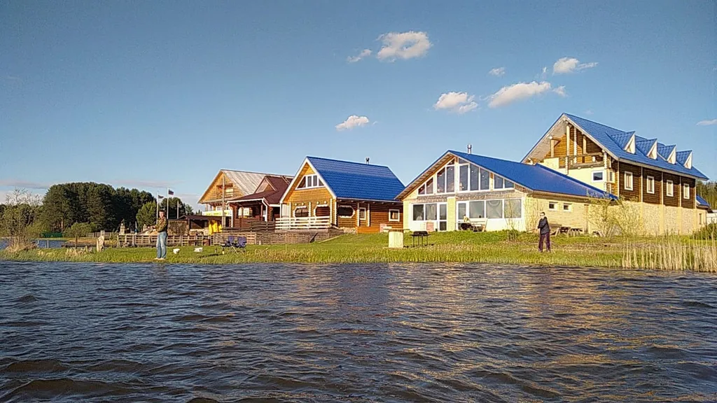 Уютный деревянный домик на берегу пруда с баней