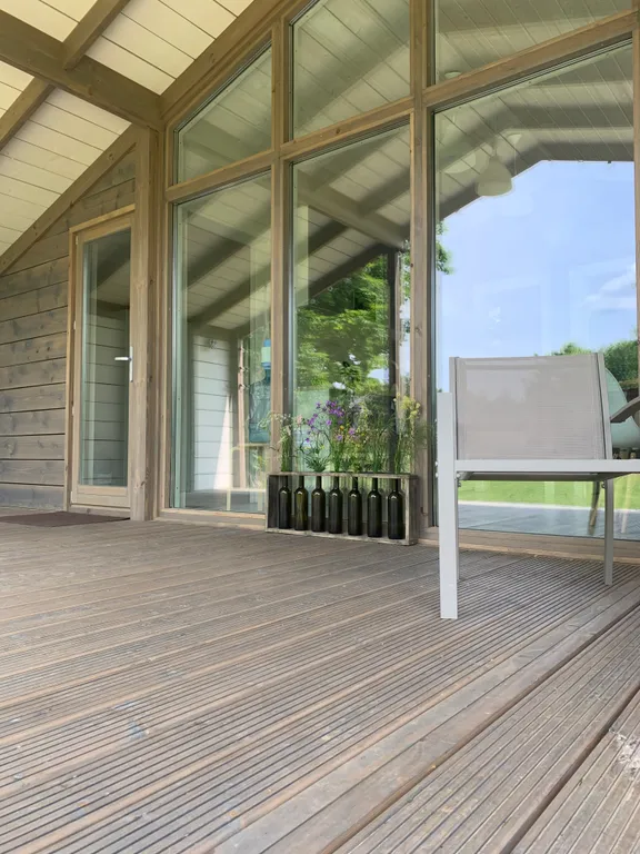 Дом с панорамными окнами в окружении леса