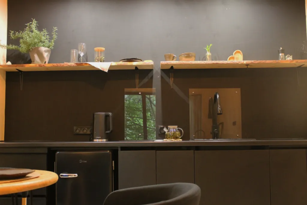 Дом с ванной у панорамных окон и высокой террасой в лесу