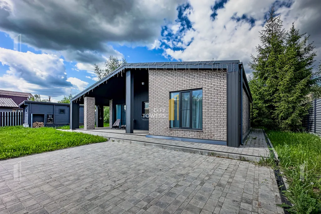 Новый дом в окружении елок с панорамными окнами и баней