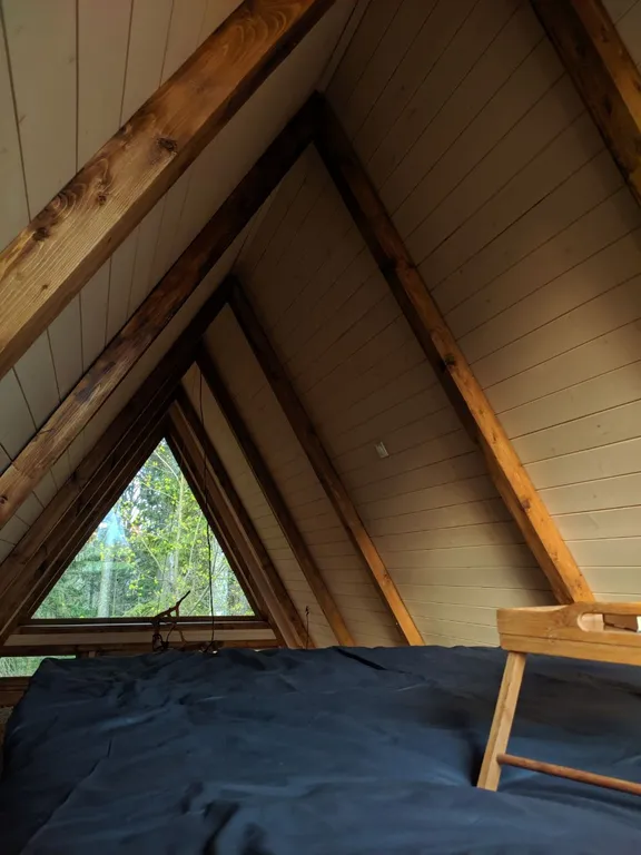 Лесной домик a-frame с террасой на холме, среди высоченных елей и берез