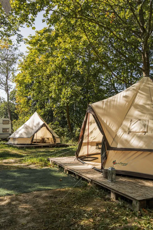 Уютный шатер среди деревьев на берегу озера