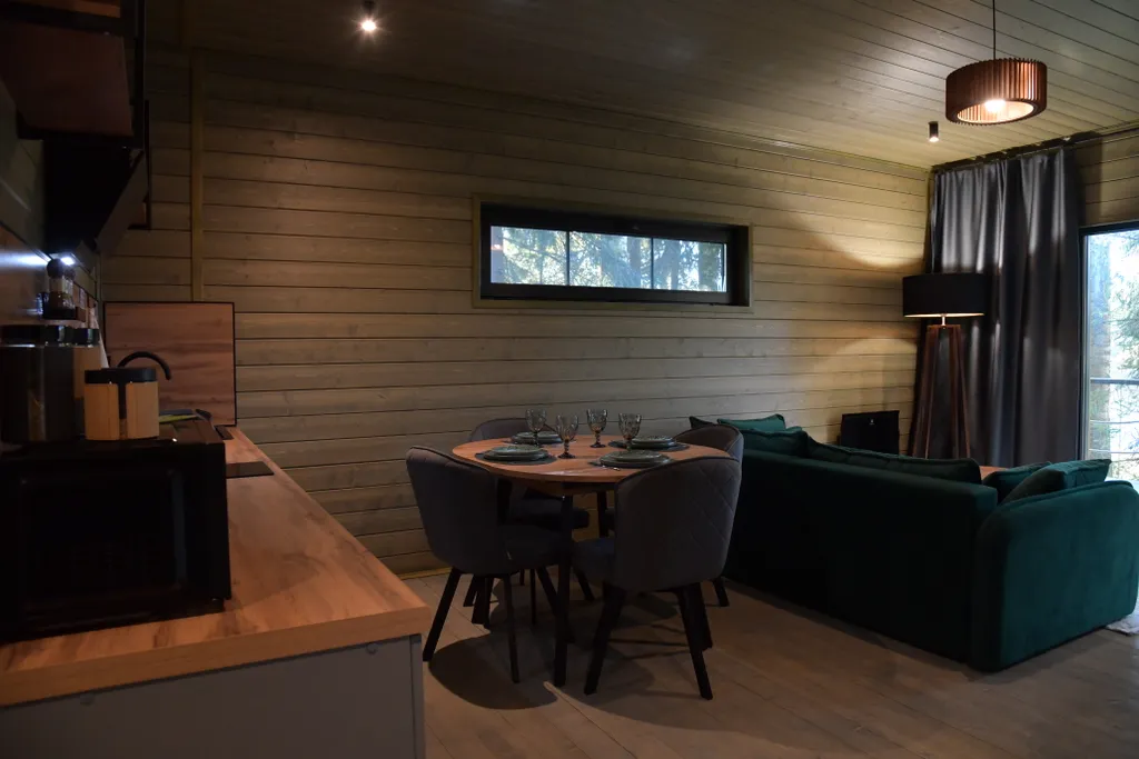 Дом с панорамными окнами в чаще леса у берега реки