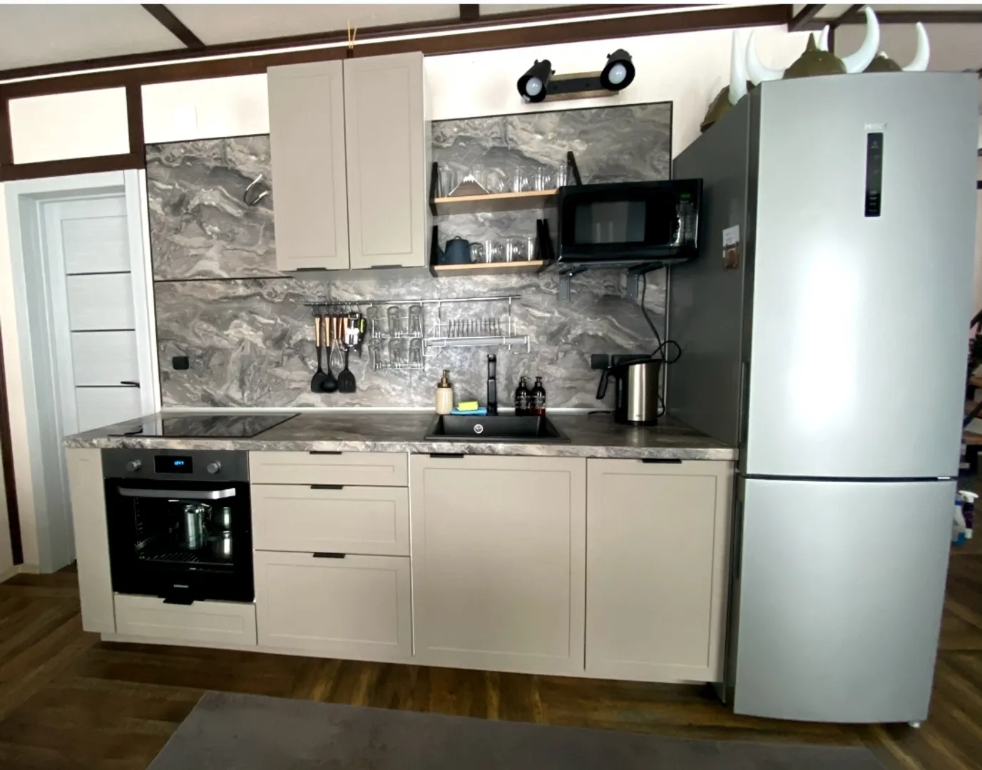 Кухня оборудована индукционной печью духовкой посудомоечной машиной чайником микроволновкой и холодильником.