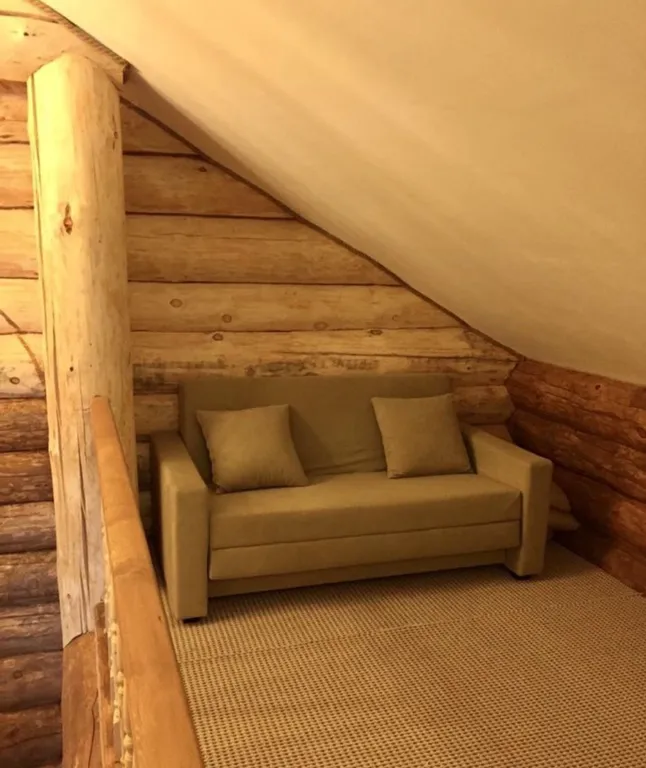 Дом из круглого дерева возле горы