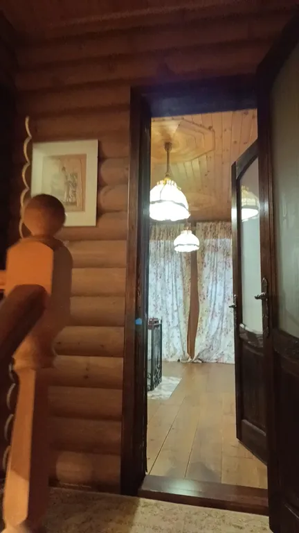 Изба (дом) из экологически чистого бревна под камышовой крышей в лесу