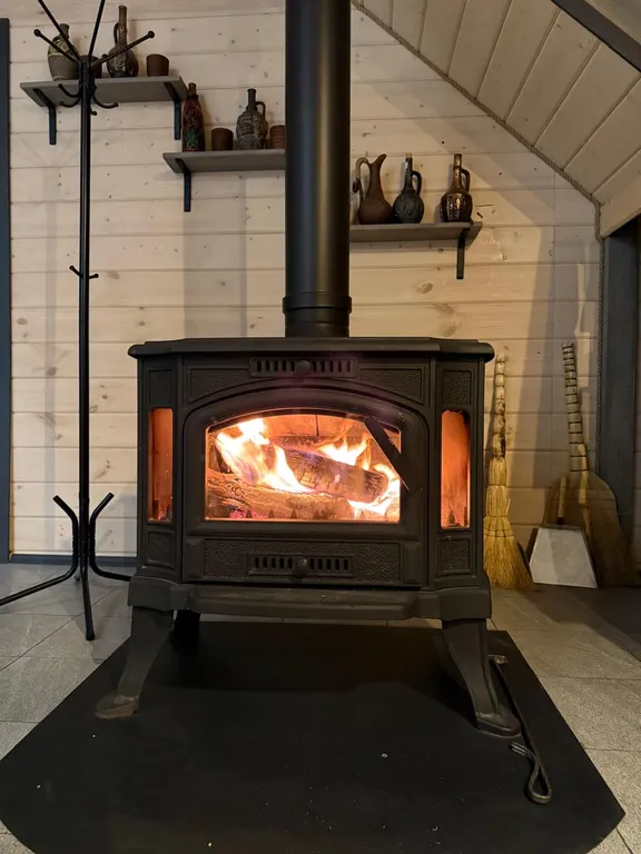 Большой треугольный домик с камином, с ванной у окна с видом на лес