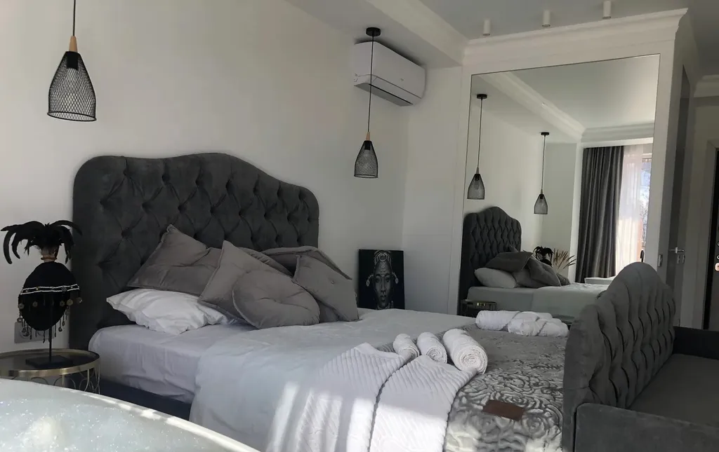 Стильная студия с ванной у панорамного окна и видом на горы