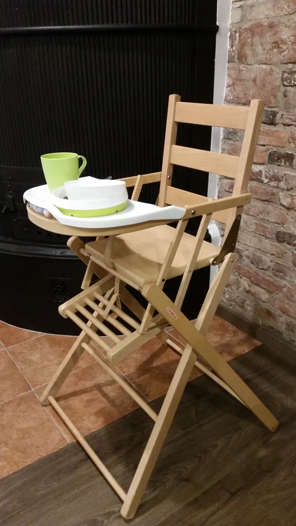 Деревянный стул для кормления и посуда для ребенка.