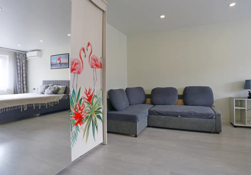 Уютная квартира в стиле лофт с комфортной кроватью и угловым диваном