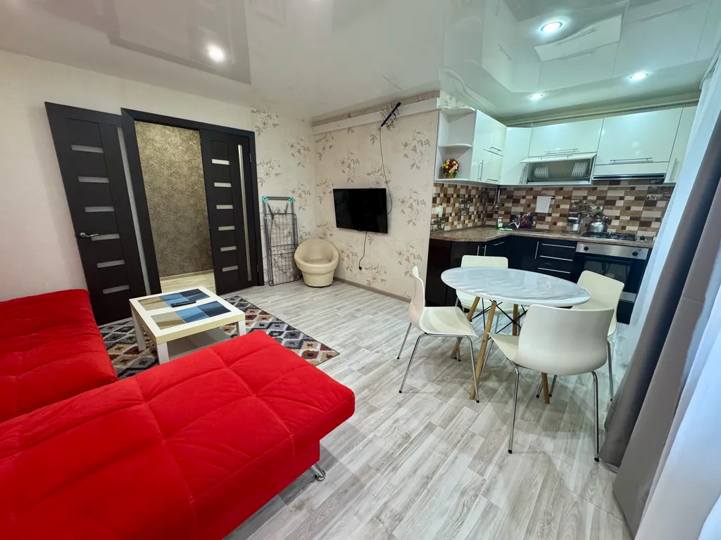 Двухкомнатная студия с красным диваном в центре города
