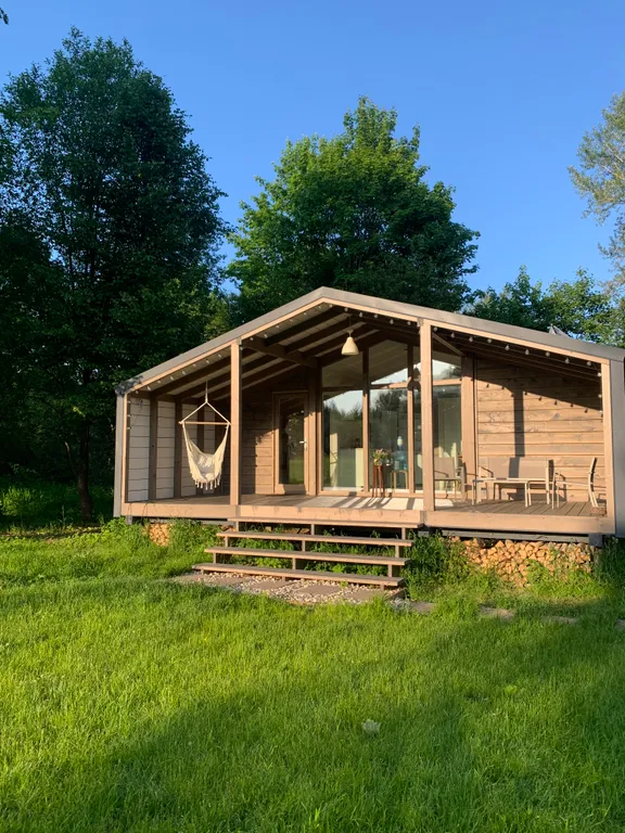 Дом с панорамными окнами в окружении леса