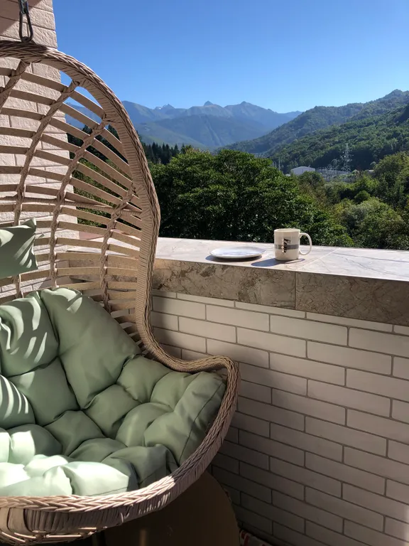 Стильная студия с ванной у панорамного окна и видом на горы