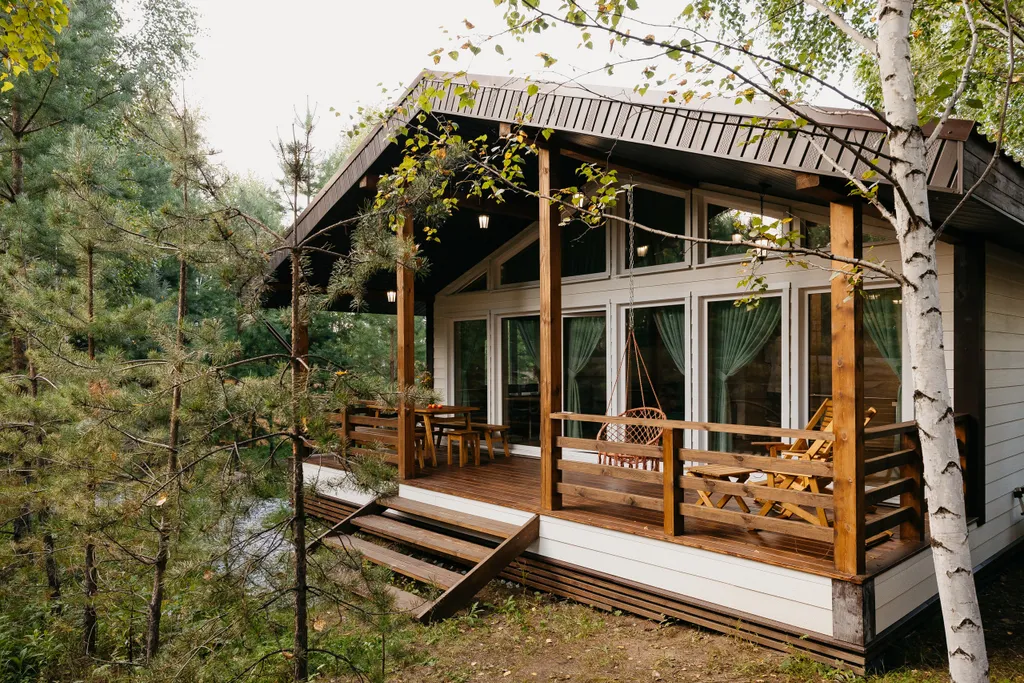 Дом с панорамными окнами и террасой в окружении леса