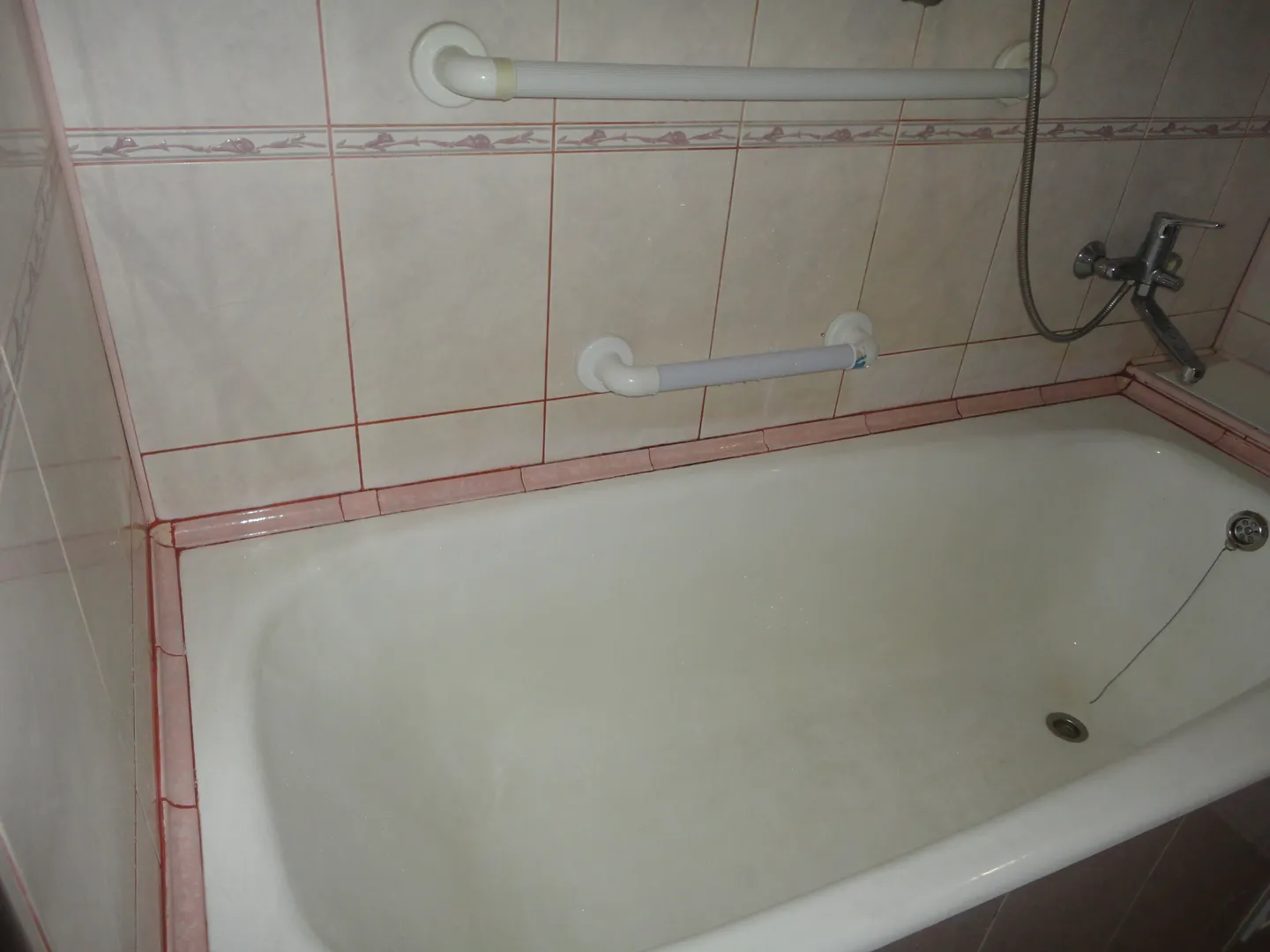 Ванная комната с розовой керамической плиткой, современной сантехникой, очень чистая и большая.