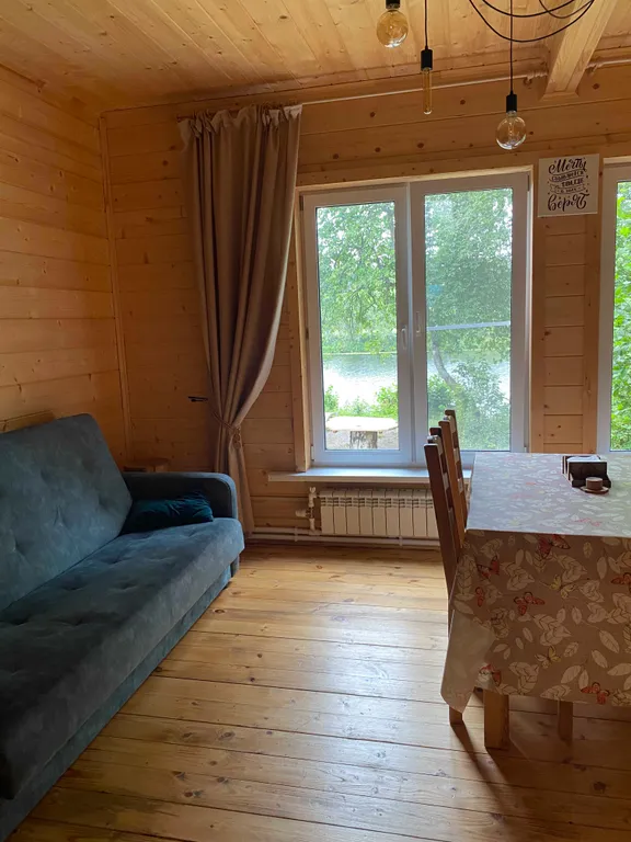 Деревянный дом на берегу реки с беседкой