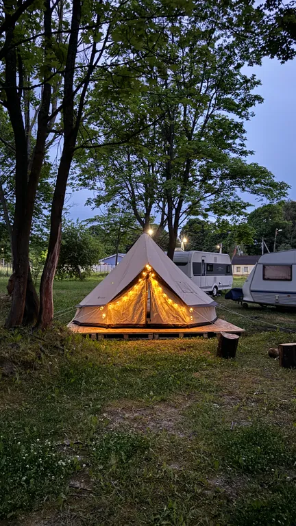 Уютный шатер среди деревьев на берегу озера