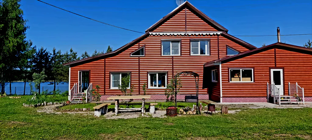 Деревенский дом в окружении леса на берегу озера