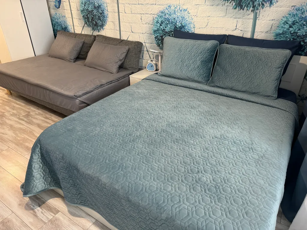 Уютная квартира-студия с большой кроватью и диваном