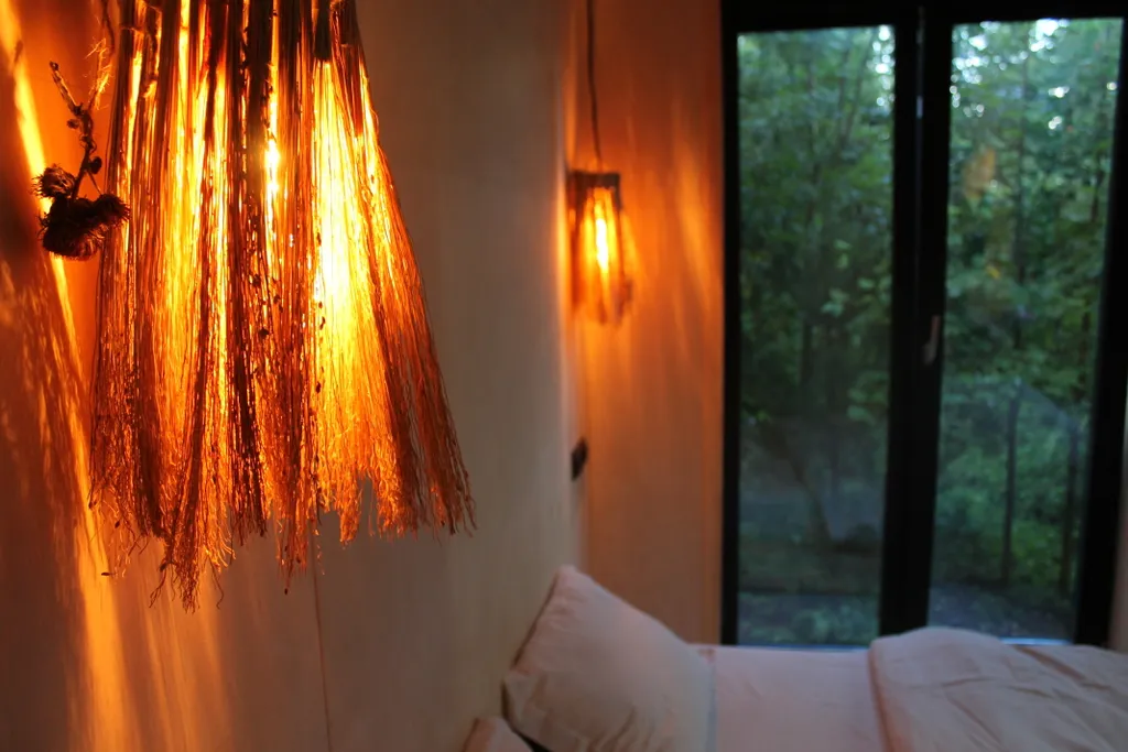 Дом с ванной у панорамных окон и высокой террасой в лесу